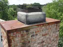 chimney with concrete chimney cap on roof