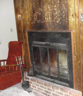 fireplace and hearth in room with red chair next to it